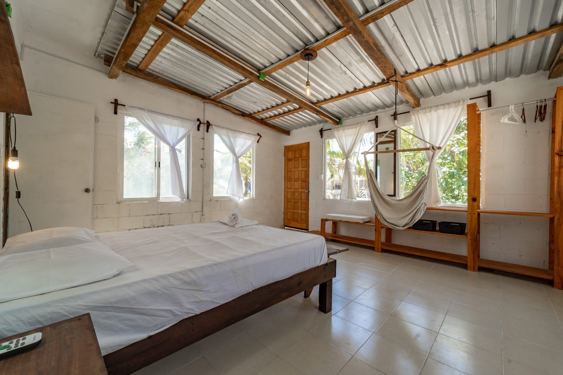 Room Fire — jungle cabin bedroom with blue bedding and windows on three sides